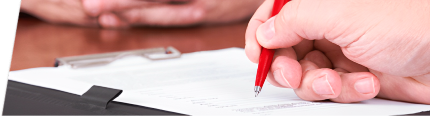 bg1 Hand signing a document with a red pen.