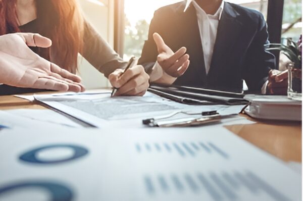 buy-and-sell-in-San-Jose_enhanced Businesspeople reviewing financial documents.
