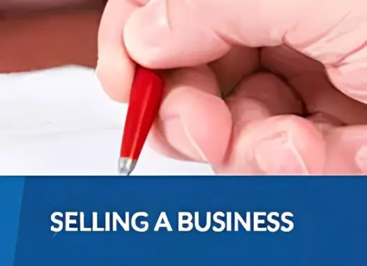 Here's an alt tag for the image: Hand signing business sale documents.